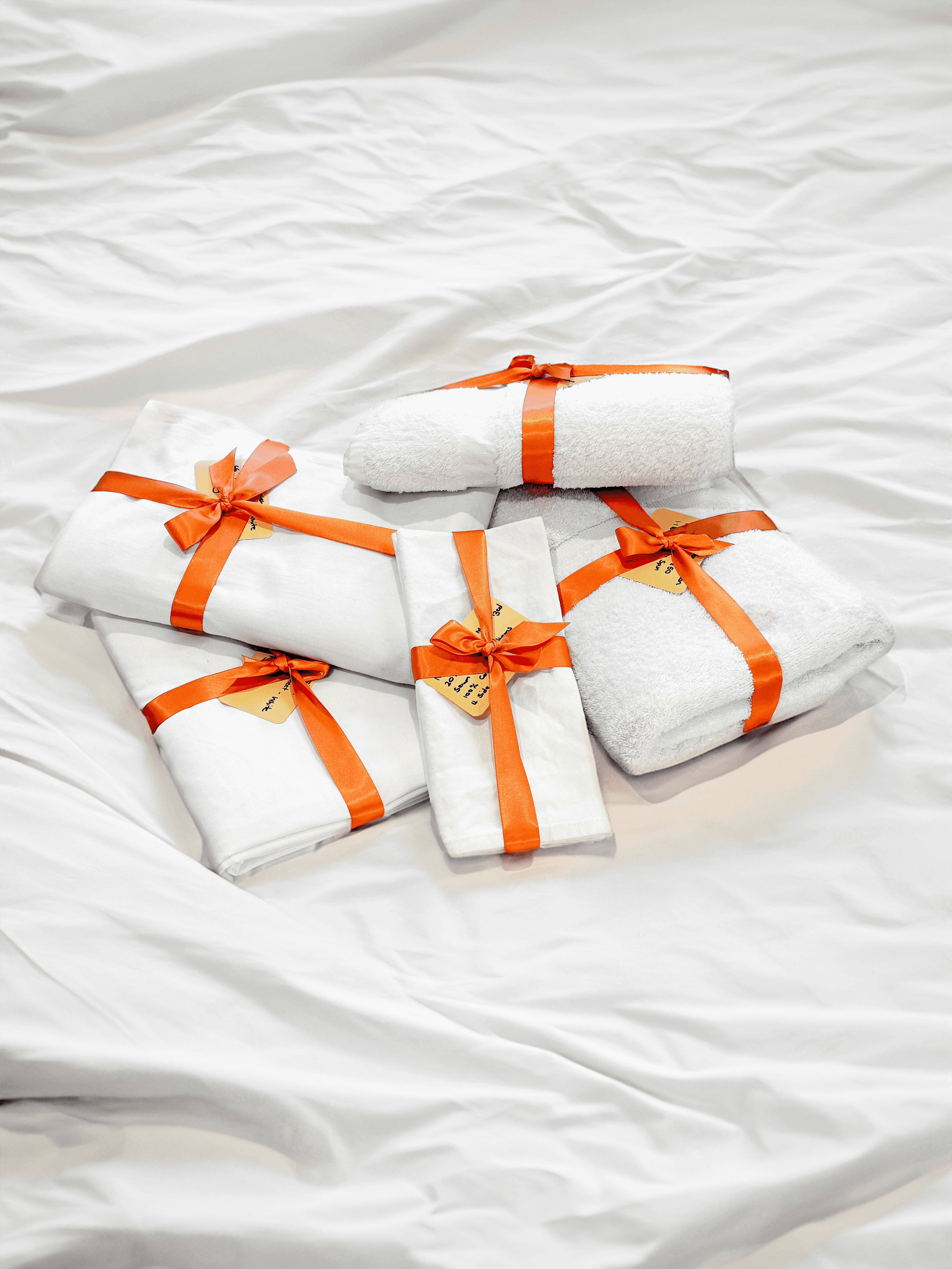Stack of neatly rolled towels tied with orange ribbons, symbolizing Fresh Wash’s attention to detail and premium wash and fold service. Perfect visual for showcasing quality in laundromat brand design and photography.